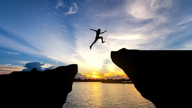 Man jump through the gap between hill