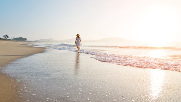 WALKING-BEACH-WOMAN-shutterstock_2313073889
