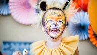 Boy in lion fancy dress laughing at children's halloween party