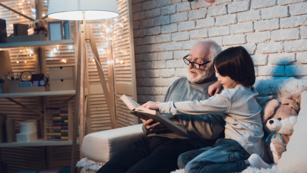 Grandfather and grandson on couch at night at home