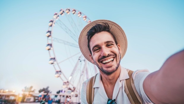 Happy man taking selfie walking on city street