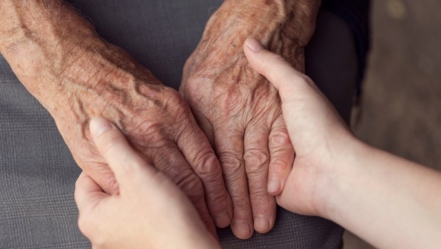Old and young person holding hands