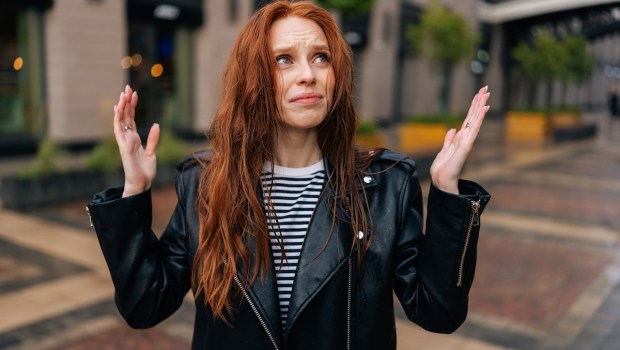 Portrait of frustrated red-haired young woman