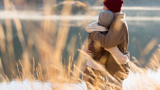 back view of lovely young couple hugging in winter