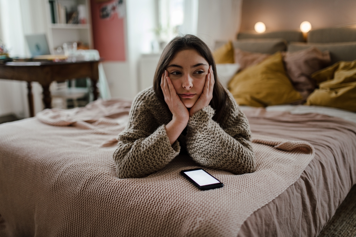 Young teenage girl with smartphone in the room
