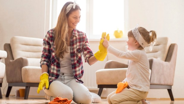 Daughter and mother cleaning home together and having fun