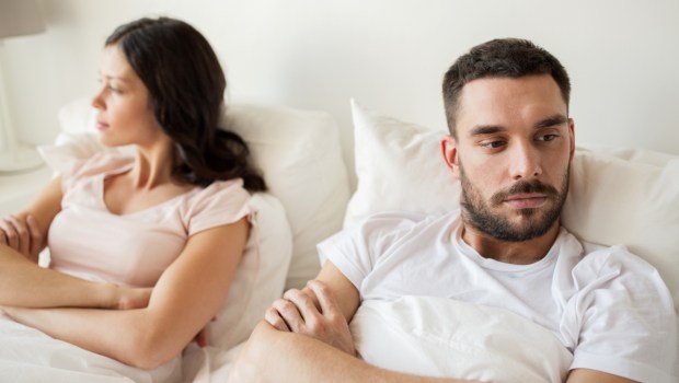 unhappy couple having conflict in bed at home