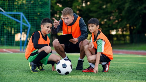 Football coach instruct teen football players
