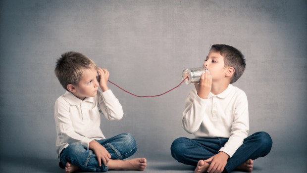 Young brothers talking with tin can telephone
