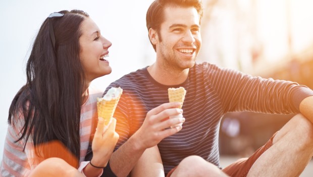 romantic couple eating ice cream at park