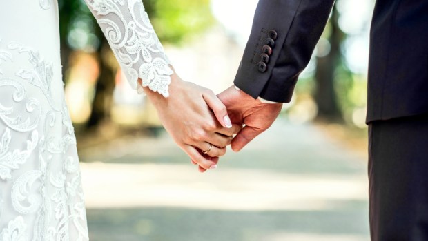 Closeup view of married couple holding hands