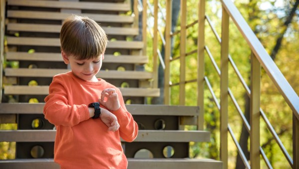 A cute boy looking at his smart watch