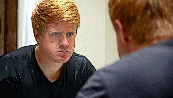 Man looking in mirror scrutinizing face
