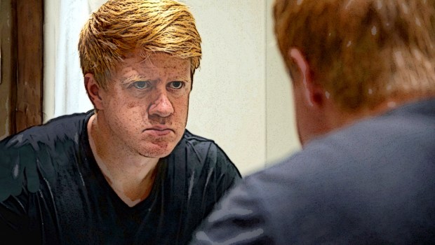 Man looking in mirror scrutinizing face