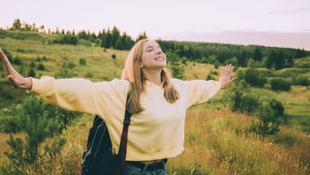 A young girl in a yellow hoodie and a backpack