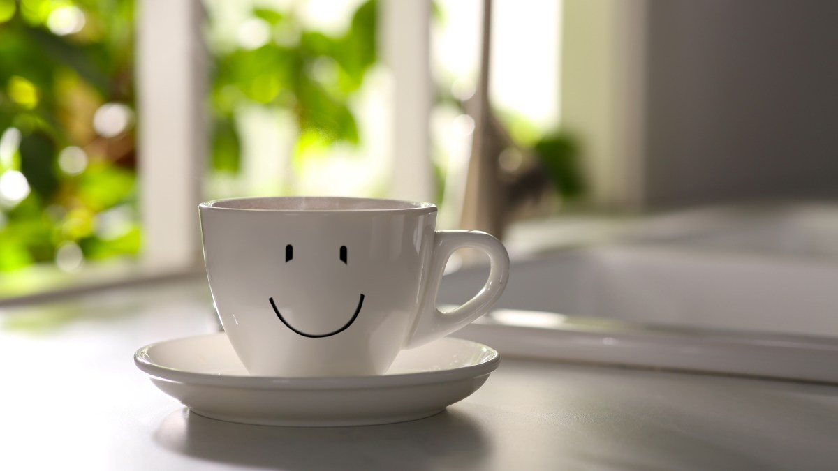 Delicious coffee in cup with happy face on kitchen countertop