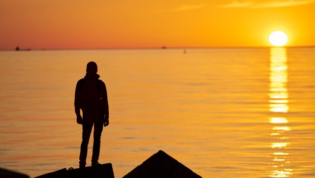 Woman or man standing on rock looking straight