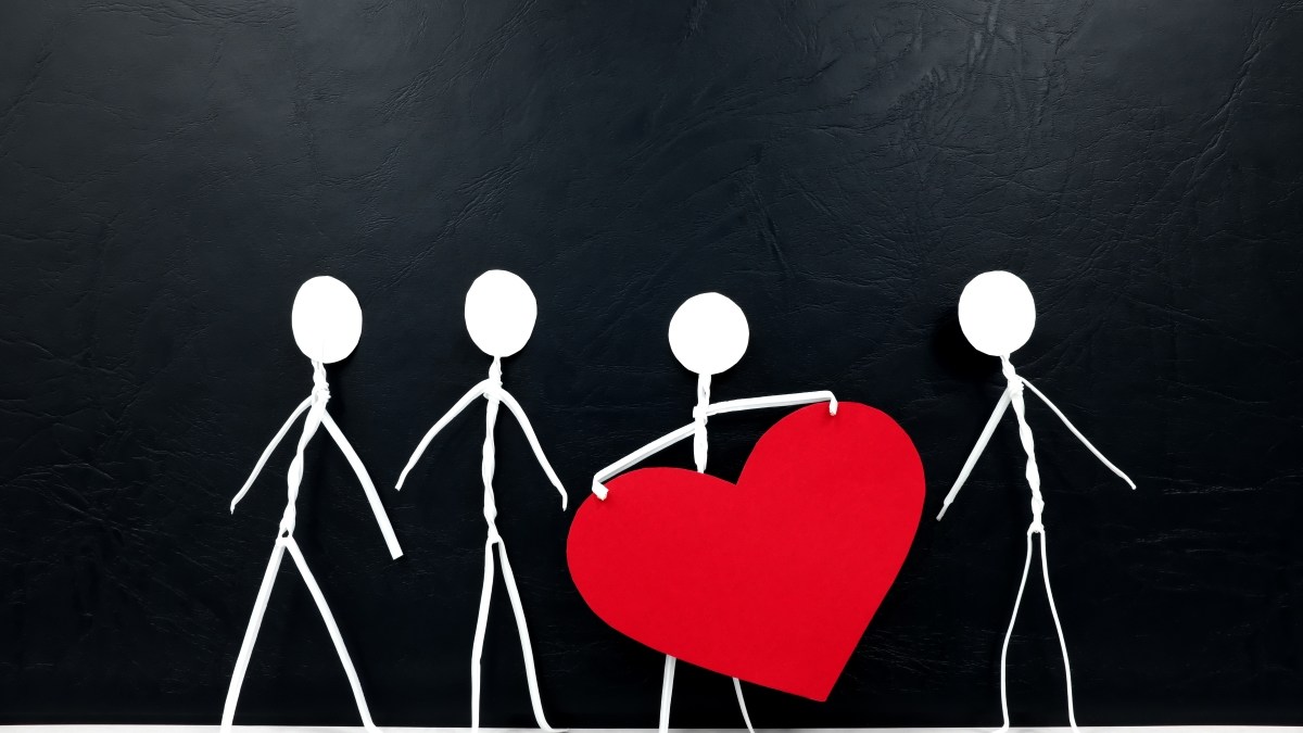 Stick man holding big red heart shape while sharing to other people