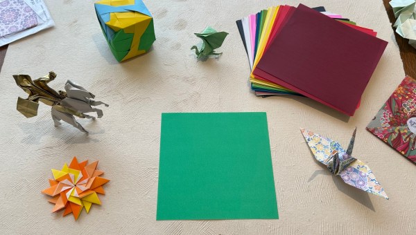 Desk with origami paper and figures on it