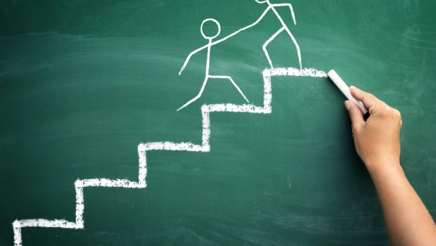 man on the top of a stairs helping an other man to climb it