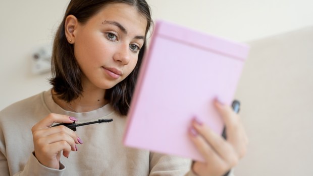 Teenage girl putting makeup