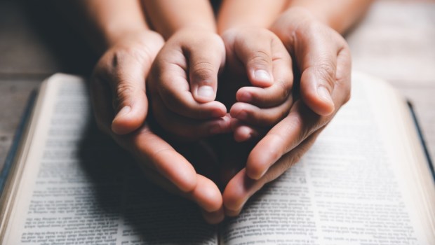 Dłonie matki i dziecka na Piśmie Świętym