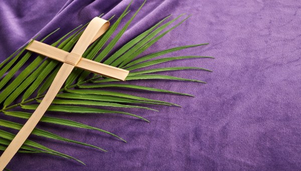 Lent season, Holy week and Good friday concept. Palm leave and cross on purple background