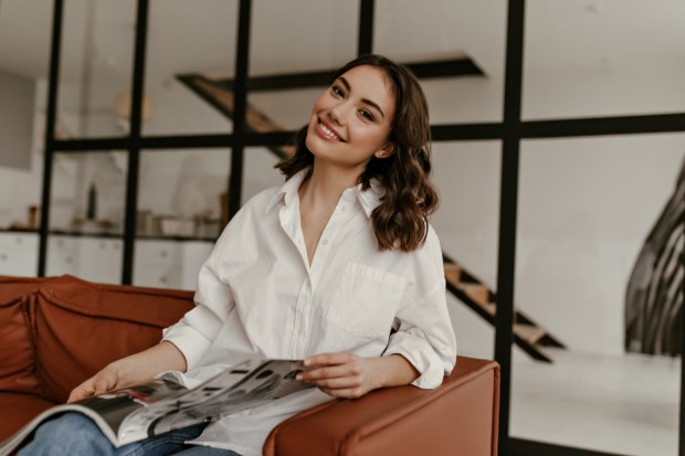 Happy brunette woman in white oversized shirt