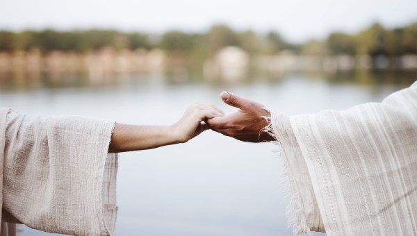 A biblical scene - of a female grabbing the hand of Jesus Christ with a blurred background