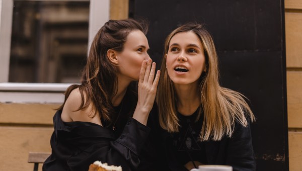 Two beautiful young women gossiping