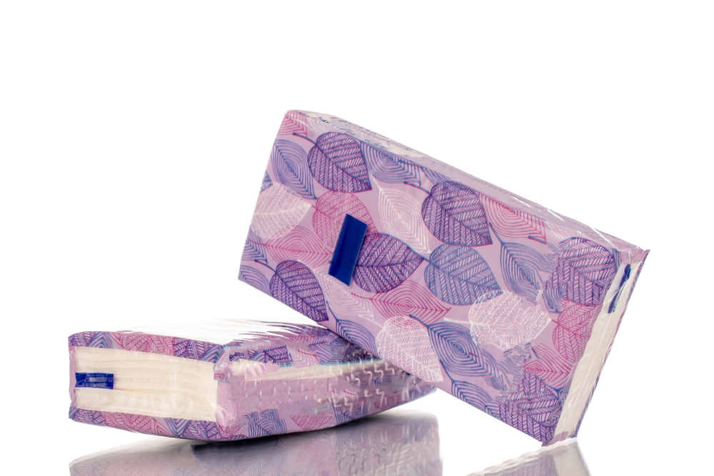 Two packs of paper handkerchiefs, close-up, isolated on white background.