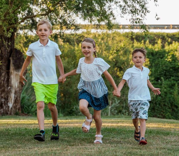 Three children running outside