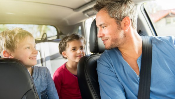 Father talking with his two kids in the car.