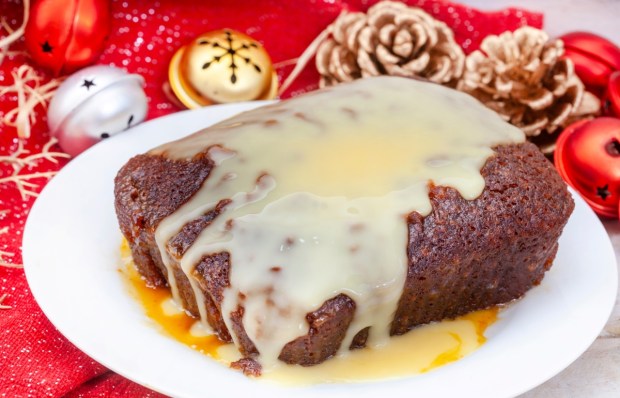 Traditional South African Malva pudding with creamy custard on rustic Christmas table