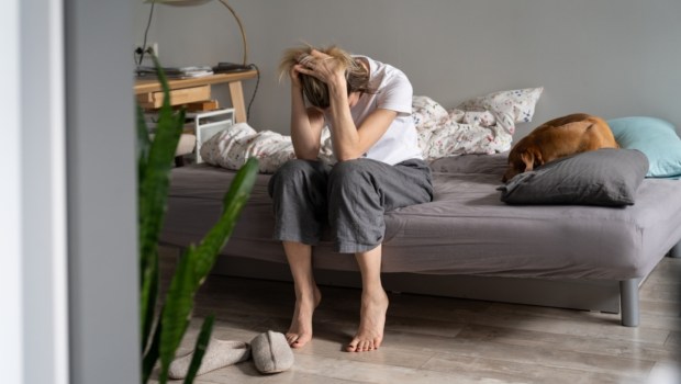 Desperate woman sitting on bed