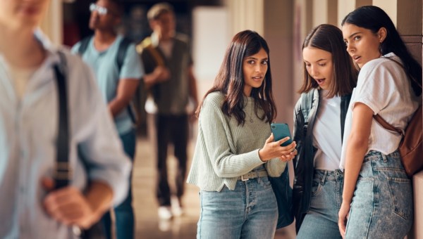 College friends, phone and gossip or fake news about students on social media, internet and mobile app with teenager group talking.
