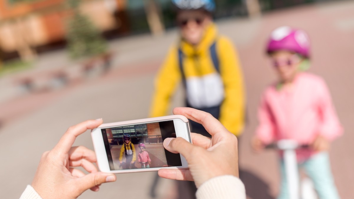 close up of hands taking picture of school children